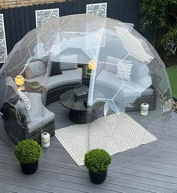 Inside a GeoDomeX dome furnished with a grey corner sofa and a rug